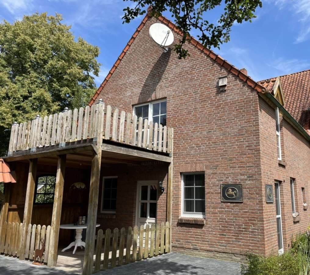 aFerienwohnung Wietzendorf: Altes Stallgebäude von 1927 - Backsteinhaus mit überdachter Holzterrasse und Balkon im Grünen